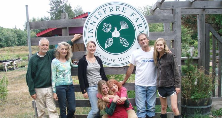 Photo of people from Innisfree farm with seal of farm