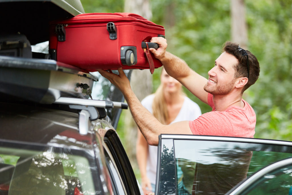 packing suitcase onto car roof